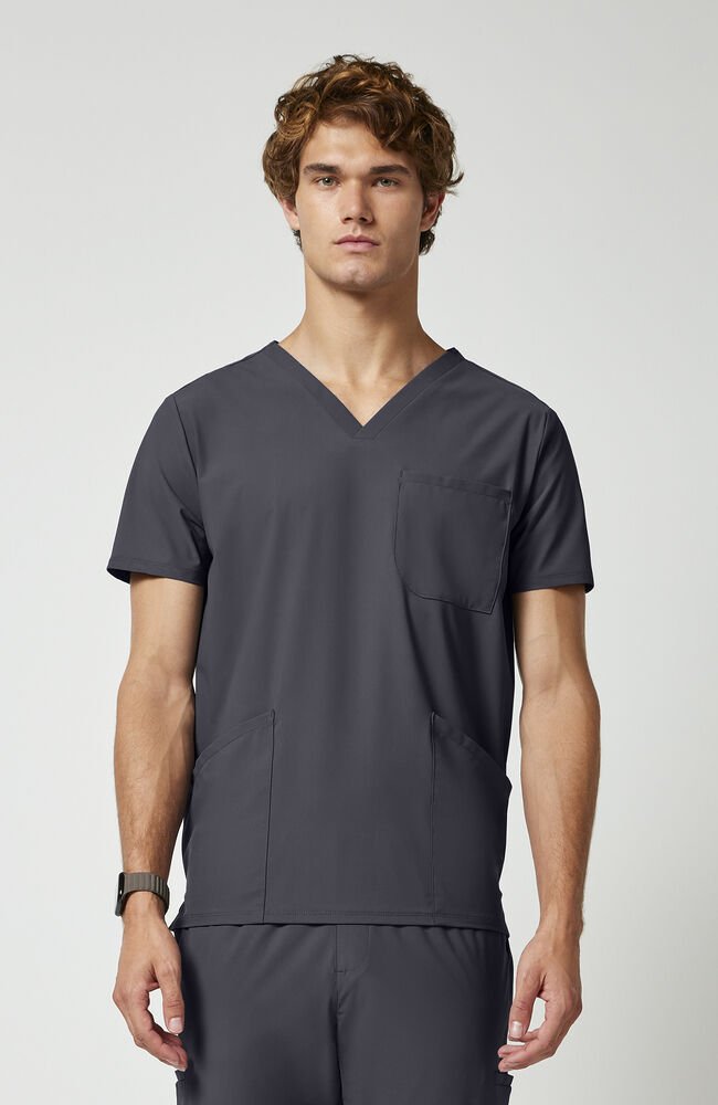 Scrubs caballeros gris Con tres bolsillos delanteros, un clip para placa en el hombro y aberturas laterales para mayor libertad de movimiento, esta prenda básica te permite tener tus imprescindibles a mano sin añadir volumen.